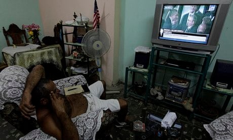 Cuban man watches Castro and Obama on TV