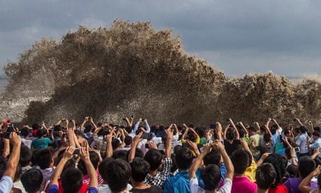 Visitors take pictures of tidal waves under the influence of Typhoon Usagi in Hangzhou