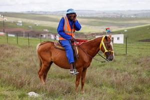 Mandela: A South African man speaks on a mobile phone whilst sitting on a horse