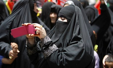 A Saudi woman films an Islamic ceremony on her phone
