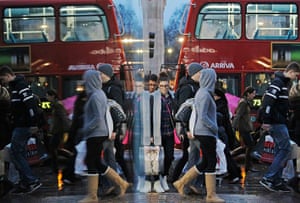 Weekend in pictures: London, England: Shoppers are reflected in a shop window as they walk along