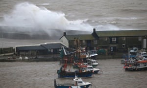 Storm waves break on the sea wall behind buildings on the Cobb in Lyme Regis. The Met Office has issued a number of severe weather warnings for heavy rain and high winds.