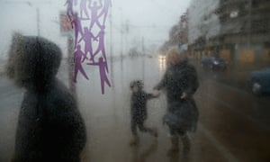 Shoppers dash for shelter in a bus stop as they brave gale force winds in Blackpool.
