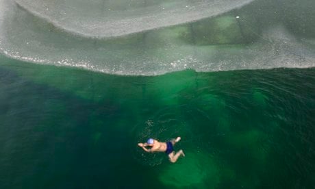 A winter swimmer swims in a partially ice-covered pond in Changzhi, Shanxi province