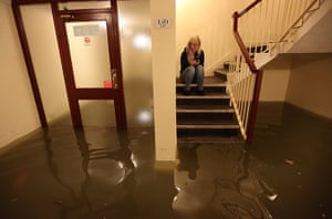 Weather UK:  A resident sits on the stairs of an appartment deep in flood water in Bost