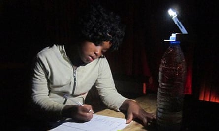A woman works by the light of a WakaWaka lamp