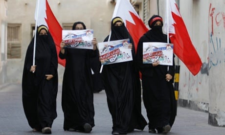 Anti-government protesters hold Bahraini flags and signs saying 'We will return till Judgment Day', as they participate in a protest in the village of Sanabis, west of Manama, Bahrain.