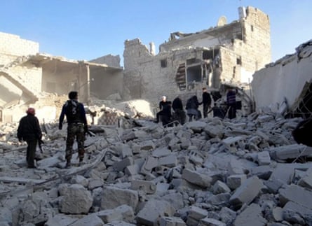 Citizen journalism image provided by Aleppo Media Center AMC, shows Syrian rebels stand in the rubble of damaged buildings due to government airstrikes, near Aleppo International Airport, in Aleppo, Syria.