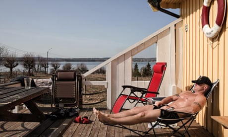 An inmate sunbathes on the deck of his bungalow on Bastoy.