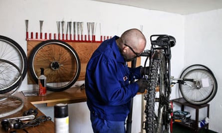 An inmate repairs a bike.