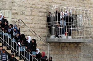 Palestinian women watch the funeral of Arafat Jaradat from a building in the West Bank village of Se'eer, near Hebron. Israeli soldiers turned out in force for the funeral of Jaradat, who was arrested just one week ago for throwing stones at Israeli cars in the West Bank.
