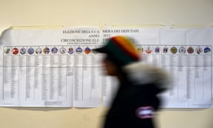 A woman passes an electoral information poster at a polling station in Rome this morning, on the second day of Italy's general election.