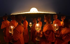 Buddhist monks hold candles as they walk around a Pagoda on Makha Bhucha Day at the Dhammakaya Temple in Pathumthani,Thailand. Makha Bhucha day is observed on the full moon of the third lunar month and commemorates the day when 1,250 monks gathered to be ordained by the Buddha.