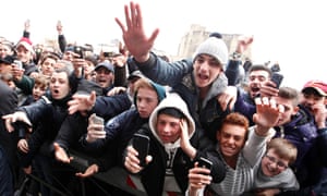 Fans gather in the street as former Argentine soccer star Diego Maradona holds a news conference in Naples.