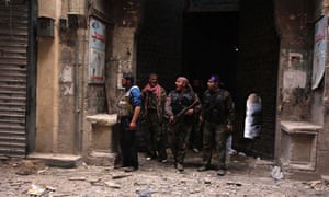 Members of the Free Syrian Army take cover during clashes against forces loyal to President Bashar al-Assad in a street in Aleppo today.