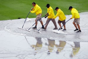 Grounds crew workers push water off the tarpaulin before an exhibition spring training baseball game between the Pittsburgh Pirates and the Baltimore Orioles in Bradenton, Florida, United states. Photograph: Charlie Neibergall/AP