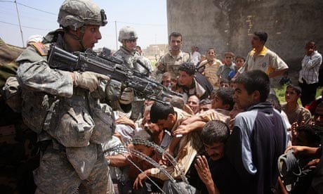 US soldier pointing gun at Iraqis