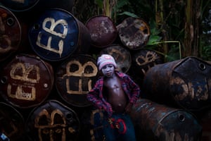 Sony World Professional: A child waits to unload drums of diesel at a jetty 
