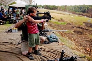 Sony World Professional: A young boy is supported as he fires a fully automatic machine gun
