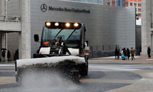 A sweeper clears snow on the plaza in front of the Mercedes Benz fashion week tents at Lincoln Center in New York.