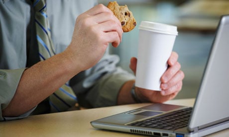 Man at desk with coffee and a cookie