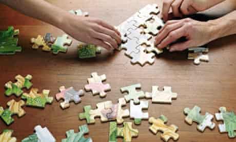 People putting puzzle together, close-up