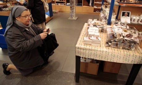 A nun takes a photograph of the first batch of souvenirs adorned with freshly-printed pictures of the newly-elected Pope Francis in a shop at the Vatican. 
