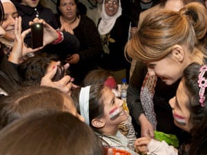 This image distributed by the Syrian presidency media office on 17 March 2013 shows Asma al- Assad being greeted by young people at a 'Mother of Martyrs' event at the opera house in Damascus.