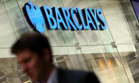 A man walks past a branch of Barclays bank