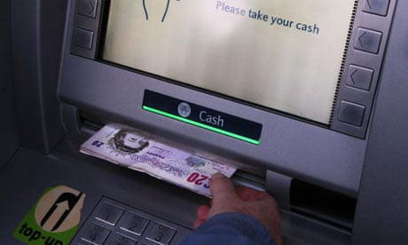 A woman uses a barclays bank cash machine