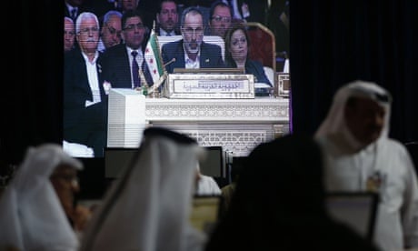 Moaz al-Khatib, head of the Syrian opposition delegation, appears on a screen as he addresses the opening of the Arab League summit in the Qatari capital Doha on March 26, 2013.