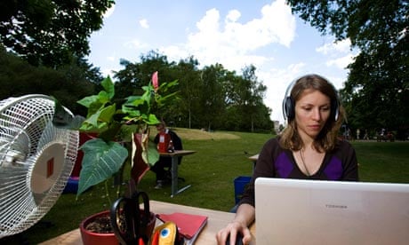 woman working at her desk in a green field