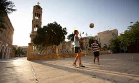 Children play football outside Phaneromeni Church near the 'green line' that separates Cyprus