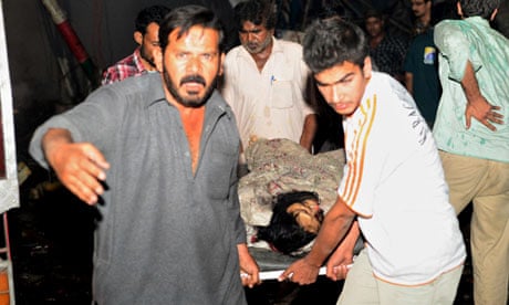 Pakistani rescuers evacuate a victim from site of blast in Karachi