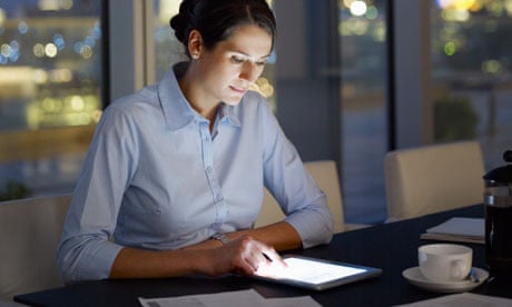 Businesswoman using digital tablet in office at night