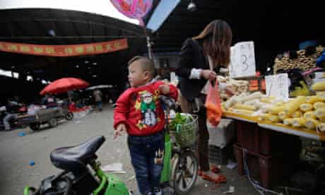 China bird flu crisis – a child waits for her mother who buys vegetable