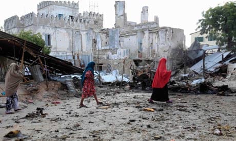 Somali women walk past the site of a deadly blast in Mogadishu