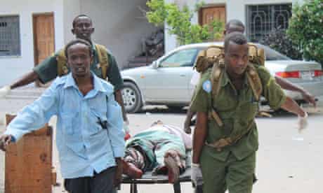 Soldiers carry a wounded civilian from the entrance of the court in Mogadishu