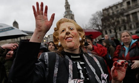A protester wears a Thatcher mask at a Trafalgar Square party to mark her death