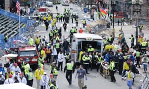 Medical workers aid injured people at the finish line of the 2013 Boston Marathon following an explosion.