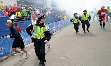 Police and runners react following two explosions at the Boston Marathon finish area.