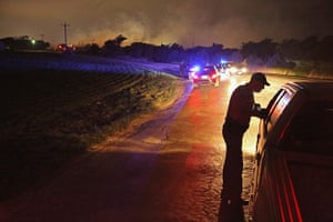 Texas explosion: With smoke rising in the distance, a law enforcement officer mans a checkpo