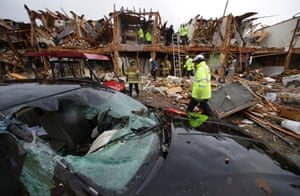 A smashed car sits in front of an apartment complex destroyed by an explosion at a fertilizer plant in West, Texas, as firefighters conduct a search and rescue Thursday, April 18, 2013.