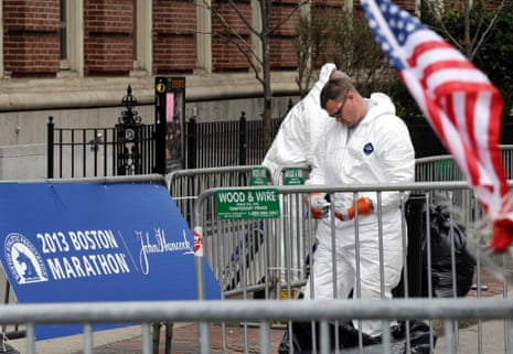 An investigator in a protective suit examines debris on Boylston Street in Boston Thursday, April 18, 2013 as investigation of the Boston Marathon bombings continues.