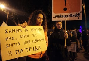 A Cypriot woman holds a banner which reads in Greek, "today our money, tomorrow our houses, and the day after our country" during a demonstration in Nicosia. Finance Minister Michalis Sarris resigned, hours after a probe was launched into how Cyprus was pushed to the verge of bankruptcy before having to agree a crippling eurozone bailout.