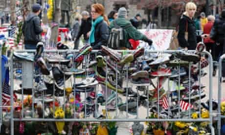 Running shoes hang from a barrier at a makeshift memorial in Copley Square in Boston. Businesses opened and traffic was allowed to flow all the way down Boylston Street on Wednesday morning for the first time since two explosions at the Boston Marathon.