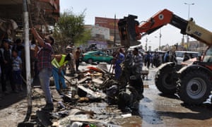在巴格达以南的Diwaniya省发生汽车炸弹爆炸后,街道清洁工拆除了路面上的碎片。