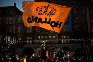 Netherlands inauguration: A man waves a flag in Dam square