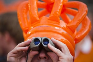 Netherlands inauguration: A man wearing an inflatable crown looks up at the balcony 