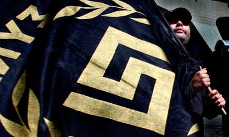 A member of Golden Dawn holds a flag bearing the party's logo